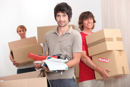 Packed moving boxes and furniture being loaded for Putney removal services