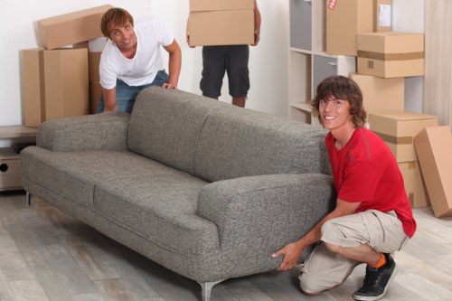 Trained movers using PPE while loading furniture safely into a van